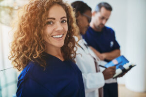 Le personnel hospitalier en blouse bleue qui est au travail en souriant.