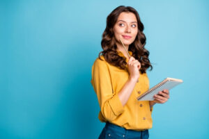 Une jeune femme souriante est en train de réfléchir.