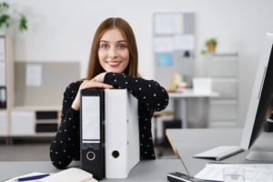 Jeune femme souriante faisant sa comptabilité dans son entreprise