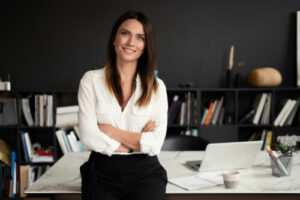 Une femme juriste se tient assise sur son bureau et sourit