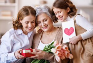 Trois générations de femme, la grand mère, la maman et la fille, s'offre des cadeaux pour la fête des mères.